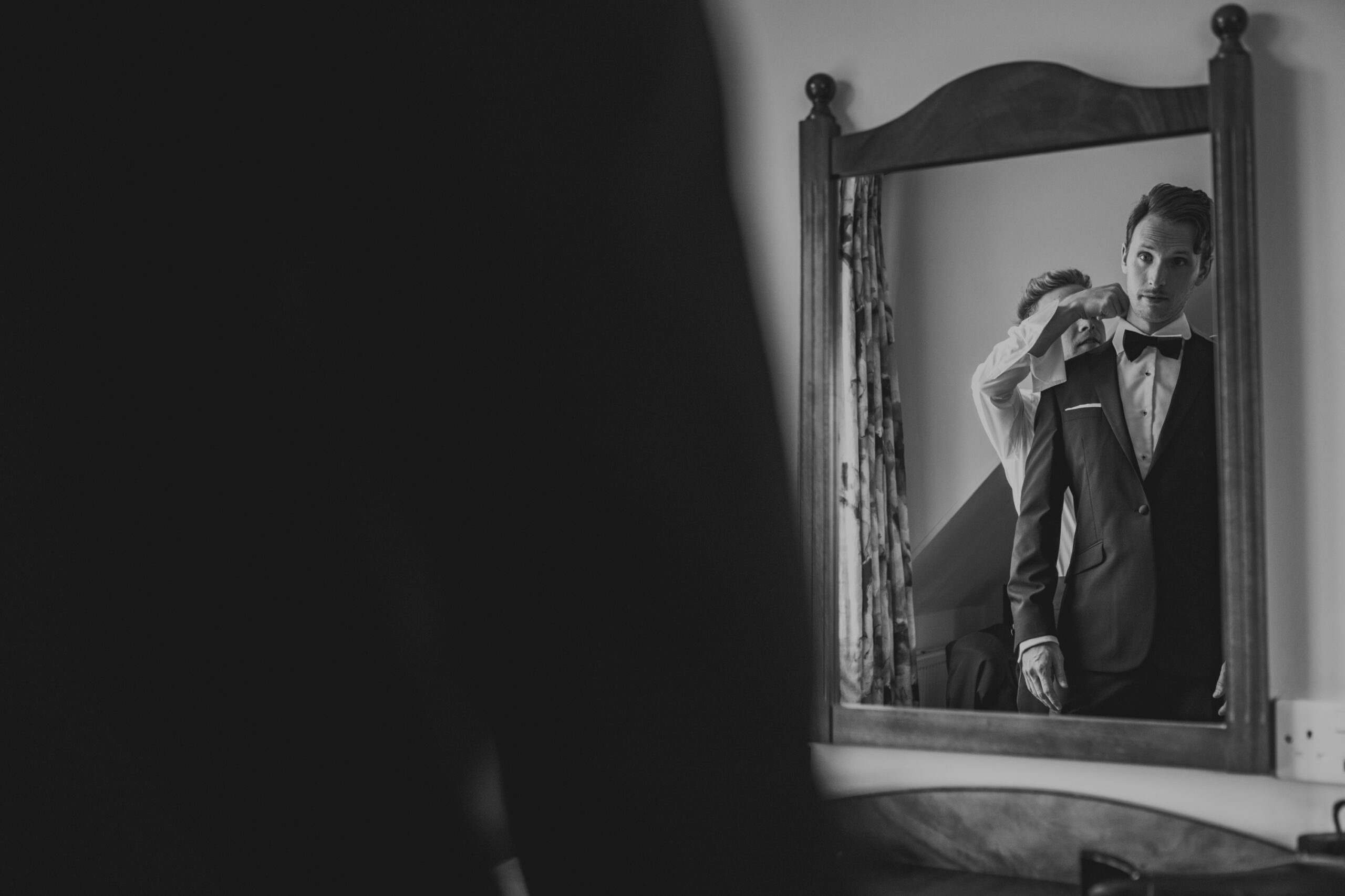 Groom checking himself in the mirror and checking one last time